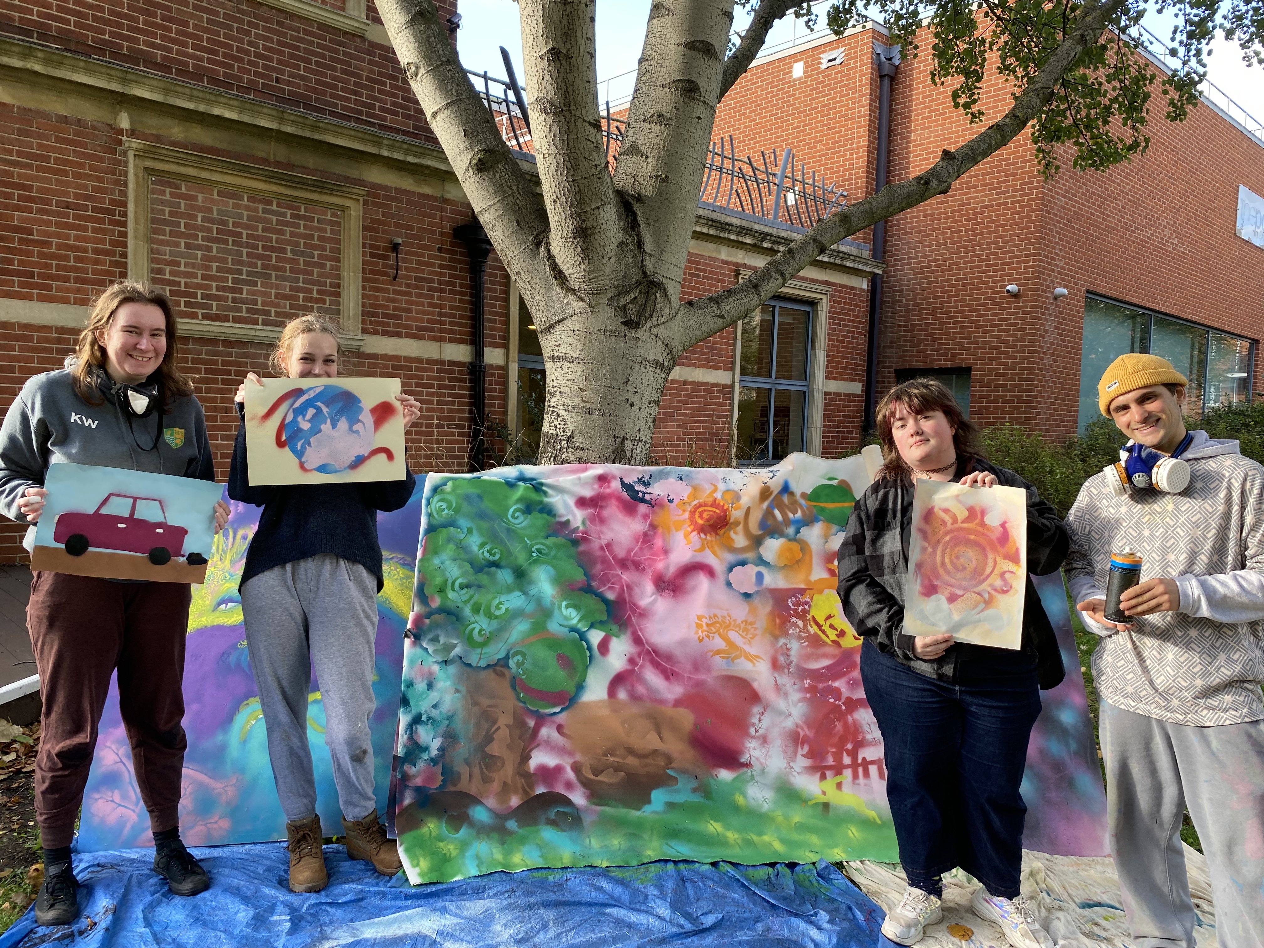 Young people holding ip grafitti/poster designs